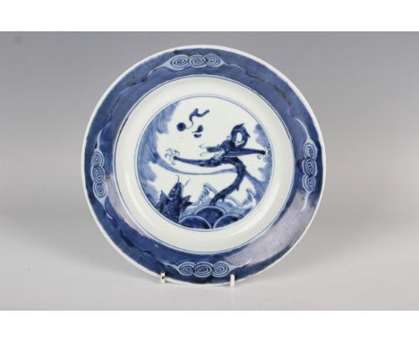 A Chinese blue and white porcelain circular dish, Kangxi period, the centre painted with a dragon chasing a flaming pearl abo