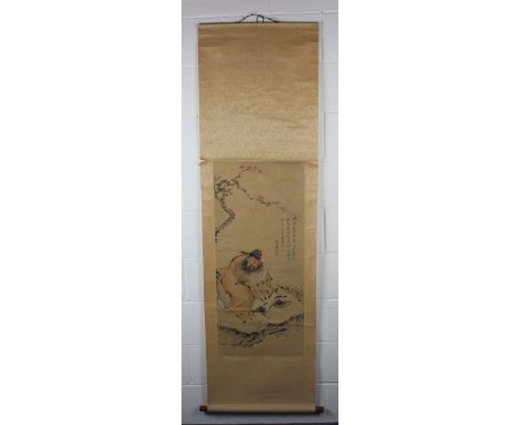 A Chinese scroll painting, late Qing dynasty, depicting a scholar seated beneath a prunus branch, four lines of black text an