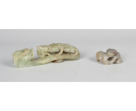 A Chinese pale celadon jade belthook, 20th century, of typical serpentine form, carved and pierced with a chilong confronting