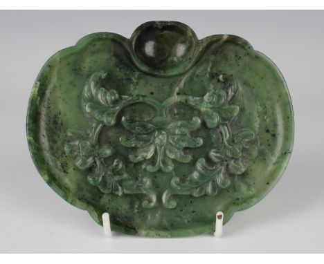 A Chinese spinach green jade ruyi-shaped dish, Qing dynasty, the interior carved in relief with lotus and scrolling leafy ten