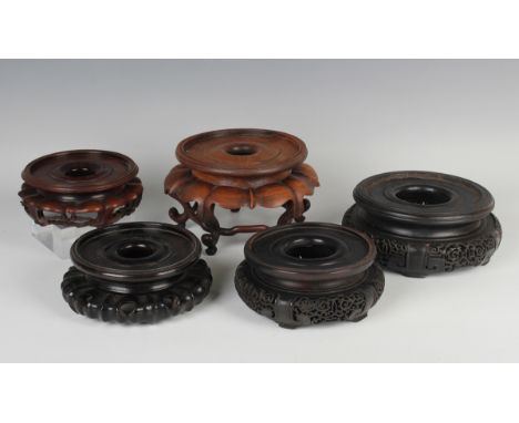 A collection of forty-five Chinese wood stands, late 19th century and later, including two circular stands with carved and pi