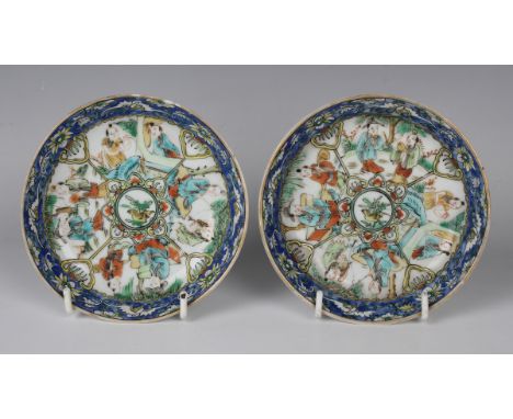 A pair of Chinese porcelain saucers, late Qing dynasty, each painted with segmented famille verte figural panels beneath a bl