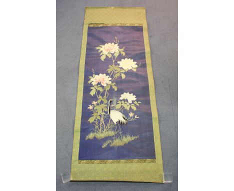 A Japanese silk embroidered hanging scroll, Meiji period, worked in coloured threads with a red-capped crane and peony on a b