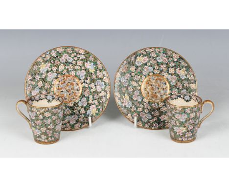 A pair of Japanese Satsuma earthenware cups and saucers by Ryuzan, Meiji period, each painted and gilt with dense polychrome 