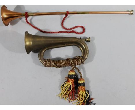 An early 20thC brass bugle, with a cord rope twist handle, 30cm wide, and a copper and brass hunting horn. (2)