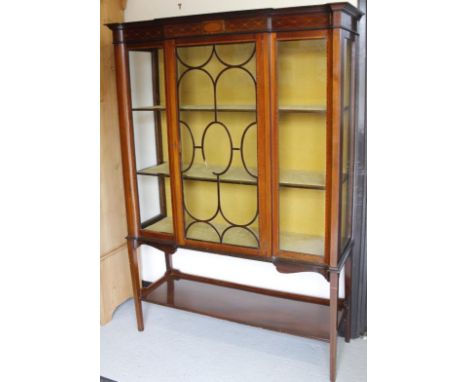 An Edwardian mahogany and boxwood strung display cabinet, the breakfront surmounted by an inlaid frieze with a central astrag