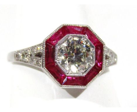 An 18ct gold diamond and ruby ring, with central stone in octagonal setting on white metal shank with diamonds to the shoulde