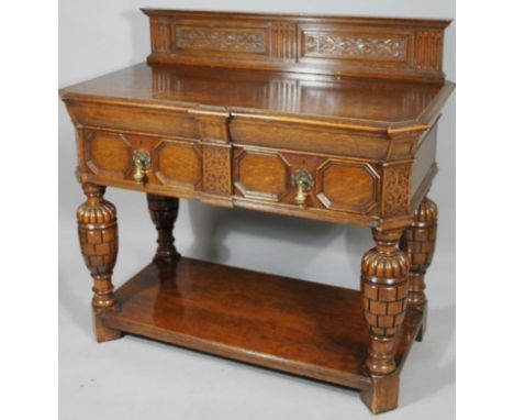 A Jacobean Revival oak serving table or buffet, with a carved gallery back above two frieze drawers with octagonal panelling 