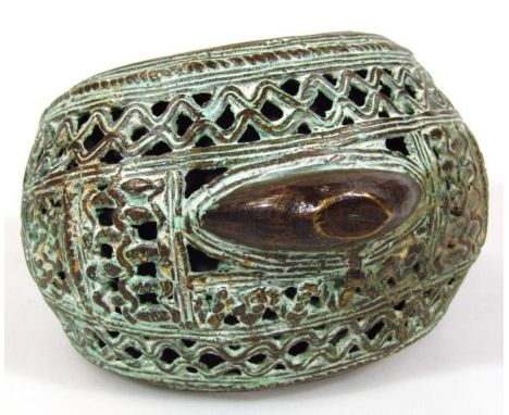 A heavy African metal bangle, of highly elaborate 'C' shaped outline, partially pierced, 13cm wide.