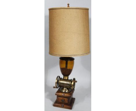 A brass hardwood and glass coffee grinder table lamp, with hessian style shade above a shaped centre and articulated base wit