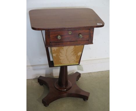 A William IV mahogany work table fitted with a single full depth drawer over a pull out basket standing on a tapered column w