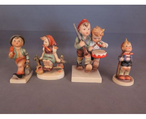 Four Goebel figures including drummer boy with escort, boy with umbrella and case, a girl sitting on fence and boy with walki