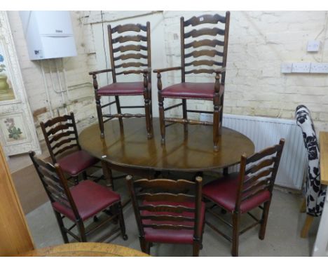 An oak drop leaf table and six ladder back chairs with red seats 