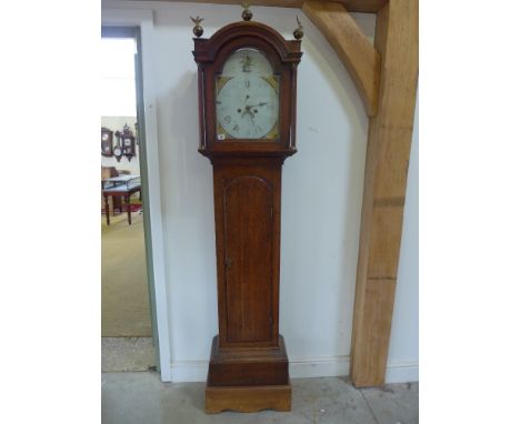 An oak eight day longcase clock with a painted 12" arched dial having calendar and secondary dial with pendulum and weights a