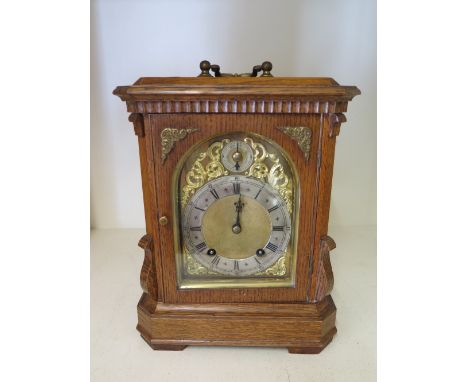 A good quality oak mantel clock with brass dial and silvered chapter ring striking on two gongs - the movement stamped W & H 