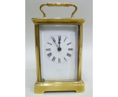 A LATE 19TH CENTURY BRASS CASED CARRIAGE CLOCK inset five bevel glass panels, hinged bale handle, white enamel dial with Roma