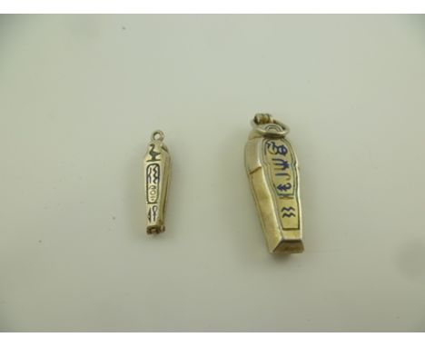 TWO EGYPTIAN REVIVAL SILVER AND ENAMEL SARCOPHAGUS PENDANTS opening to reveal mummies, c1920 both with ring mounts, one is 3c