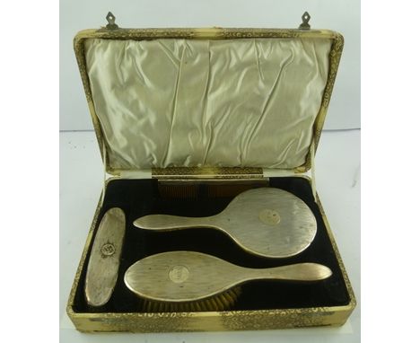 K** & L** A GEORGE V SILVER MOUNTED DRESSING TABLE SET, boxed, comprising a hand mirror, two brushes and a comb, monogrammed 