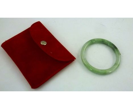 A 20TH CENTURY JADE BANGLE, interior diameter 52mm, in a red pouch 