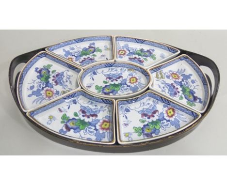 A BOOTHS HORS D'OEUVRES SET comprising an oval ebonised tray with pierced handles containing seven ceramic segmented dishes, 
