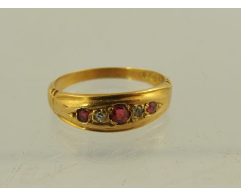 A GEORGE V 18CT GOLD RUBY AND DIAMOND DRESS RING having three rubies interset with two diamonds in a tooled setting, Birmingh