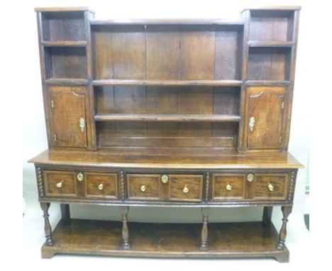 AN 18TH CENTURY DRESSER BASE, fitted three drawers with half bobbin decoration, fitted brass knob handles and decorative escu