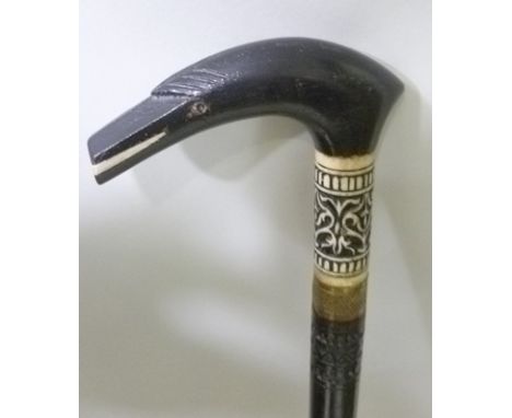 AN EARLY 20TH CENTURY INDIAN SWORD STICK, having ebonised shaft with stylised bird head handle with brass ferrule, overall 87