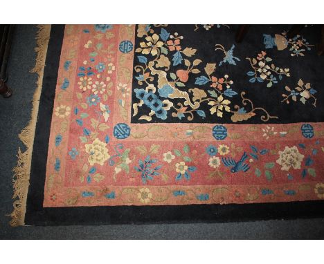 A Chinese wool carpet with central floral medallion and pattern of butterflies and floral sprays on deep blue field within pi