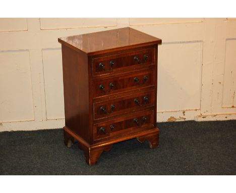 A small inlaid yew wood chest of four drawers, with rectangular cross-banded top, on shaped bracket feet, 45cm