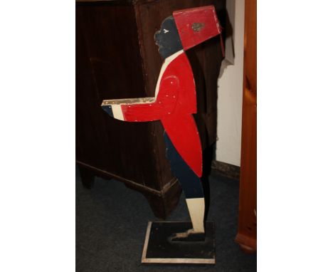 A painted wood figure of a waiter wearing a red fez with Royal Army Ordnance Corps cap badge, and red dinner jacket, 91cm (a/