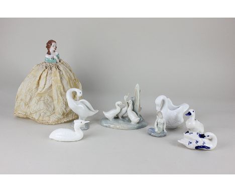 A Lladro porcelain model of a goose, 11cm, together with a Nao model of three geese, 12cm, a porcelain half doll on pincushio