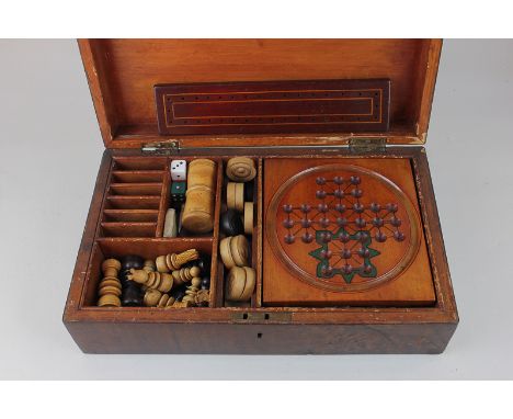 A Victorian games compendium in walnut box, containing solitaire board with marbles, dominoes, draughts, chess pieces, and ot