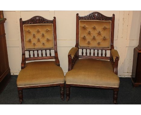 A pair of Victorian fireside king and queen chairs with foliate and shield carved surmount and button upholstered back, on sp