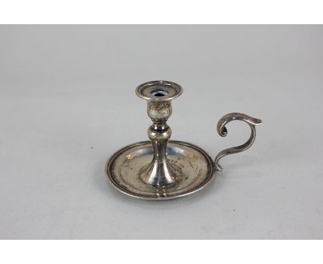 A Victorian silver taper stick with baluster stem, circular base and scroll handle, London 1872