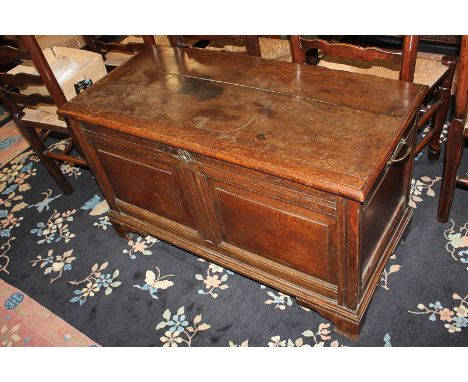 A 17th century oak coffer with moulded two-panel front containing candle box, on bracket feet, 103cm
