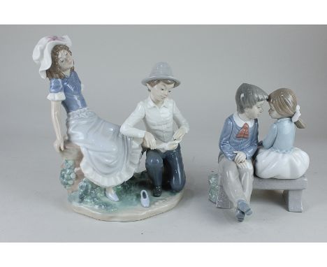 A Nao figure group of a young man tying a bandage round a lady's foot, 22cm, and another of a young couple on a bench, 18cm