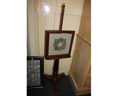 A Victorian mahogany adjustable fire screen, with glazed needlework panel on pole and turned wood support, on platform base t