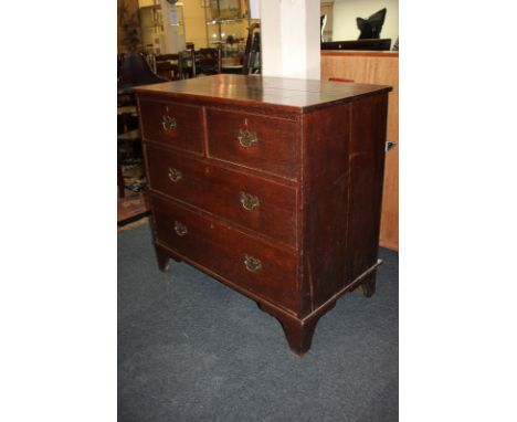 An 18th century country oak chest of two over three drawers, brass drop handles and shaped escutcheons, on bracket feet, 93cm