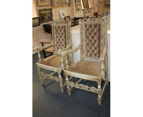 A pair of carved limed oak carver dining chairs with button upholstered panel back, with pierced scroll and floral surround, 
