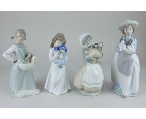 Three Nao figures of children holding two puppies, a doll and a lamb, tallest 25cm, together with another similar