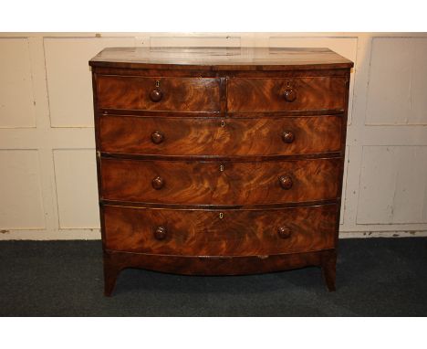 A bow-front mahogany chest of two short over three long drawers, with cross banded top, on curved bracket feet, 104cm (a/f)