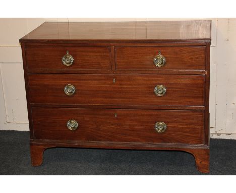 A George III mahogany flat-front chest of two short over two long drawers with circular embossed back plates and brass drop h