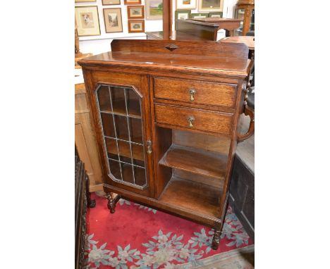 A George V oak bookcase, leaded glazed door flanked by a pair of drawers and an open shelf, barley twist legs, c.1930

