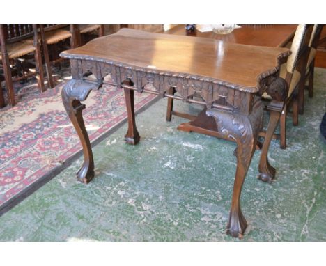 An Irish Chippendale Revival mahogany silver table, serpentine top with gadrooned edge above a shaped frieze carved with blin