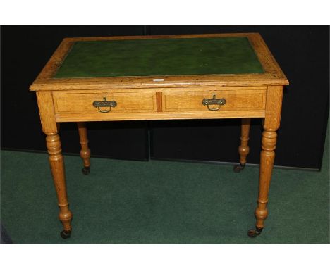 Edwardian light oak library table, with green leather inset top, two frieze drawers, on turend legs and castors, 