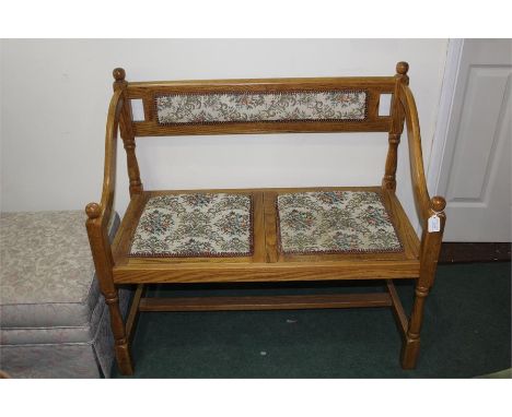 Light oak hall bench, with upholstered back and seat, down-swept arms, on turned legs and flattened stretchers, 96.5cm wide