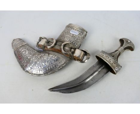 An early 20th century white metal mounted jambiya dagger and scabbard, the dagger with 17 cm (l) blade having medial ridge, w