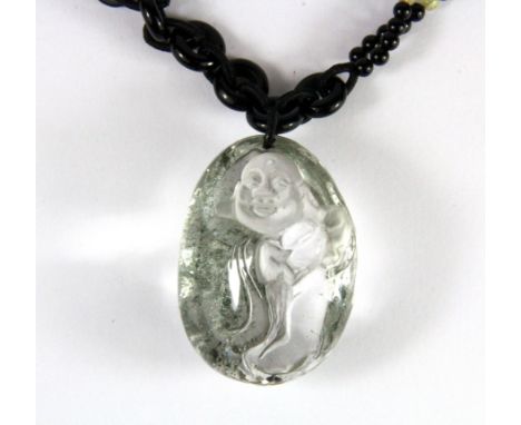 A carved rock crystal amulet of the happy Buddha, H. 5.5cm on an obsidian bead necklace.