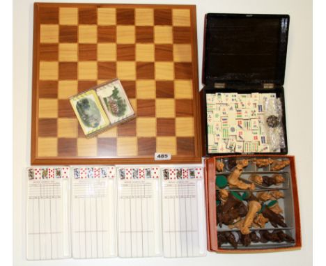 A vintage chess set, Mahjong, bridge scorers and playing cards.