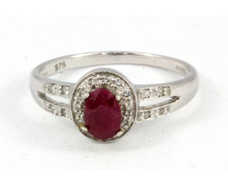A 9ct white gold ruby and diamond set cluster ring with diamond set shoulders, (O.5).